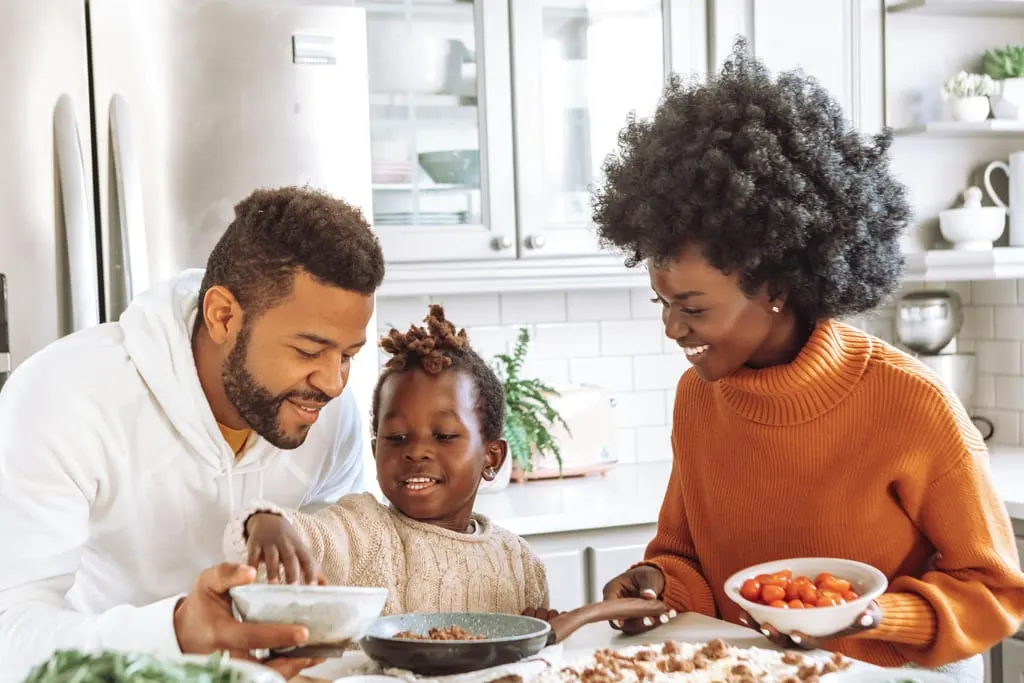 Parent and child at a calm kitchen table, the child reaching into a bowl, the kind of meal Heartful Eating Recovery works toward for ARFID and picky eating